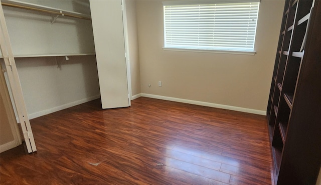 unfurnished bedroom with a closet and dark hardwood / wood-style floors