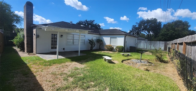 back of house featuring cooling unit, a lawn, and a patio