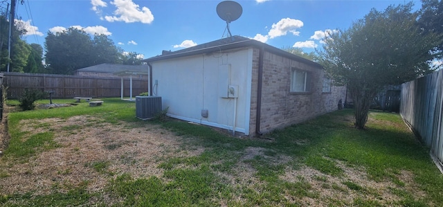 view of outbuilding featuring central air condition unit and a yard