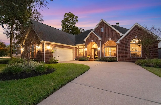 view of front of home featuring a garage and a yard