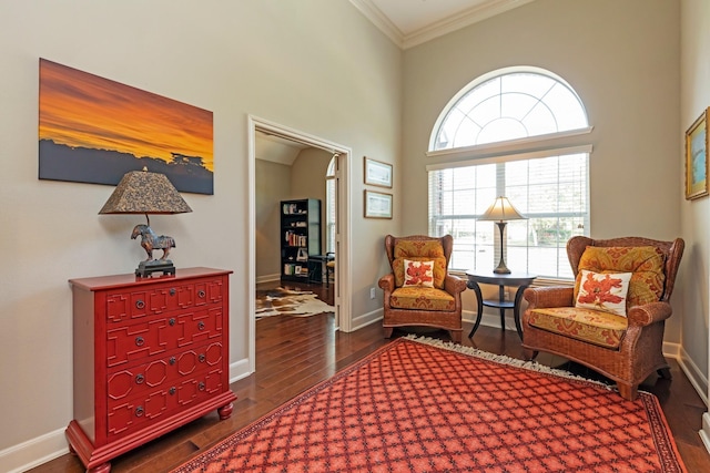 living area with dark hardwood / wood-style floors, a high ceiling, and ornamental molding