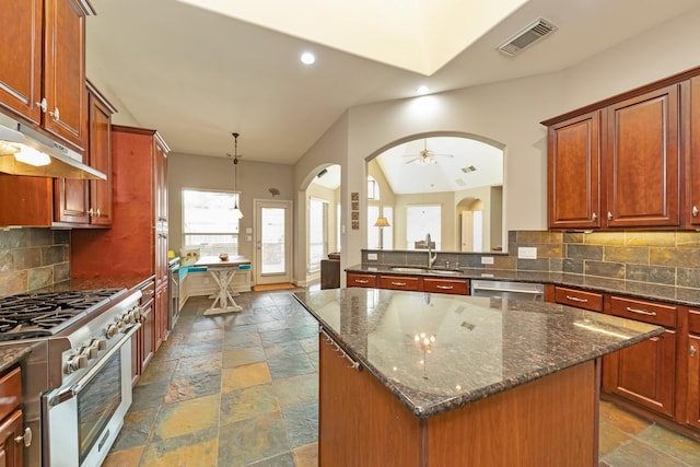 kitchen featuring ceiling fan, a center island, decorative backsplash, sink, and stainless steel appliances