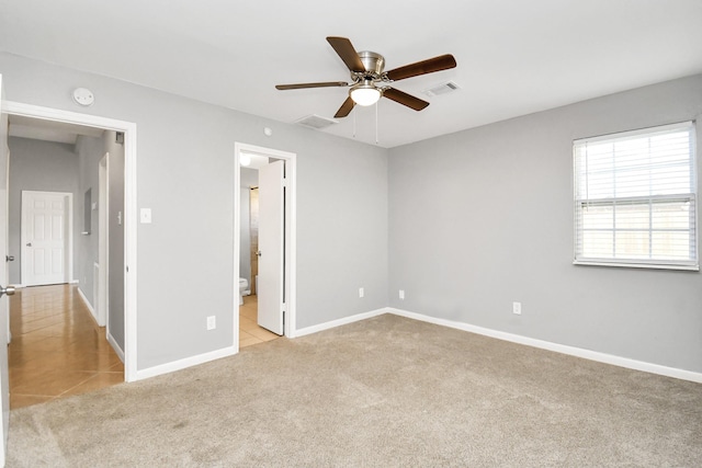 unfurnished bedroom with light carpet, ensuite bath, and ceiling fan