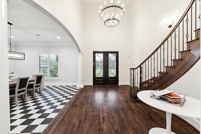 foyer with a chandelier, french doors, dark hardwood / wood-style flooring, and ornamental molding