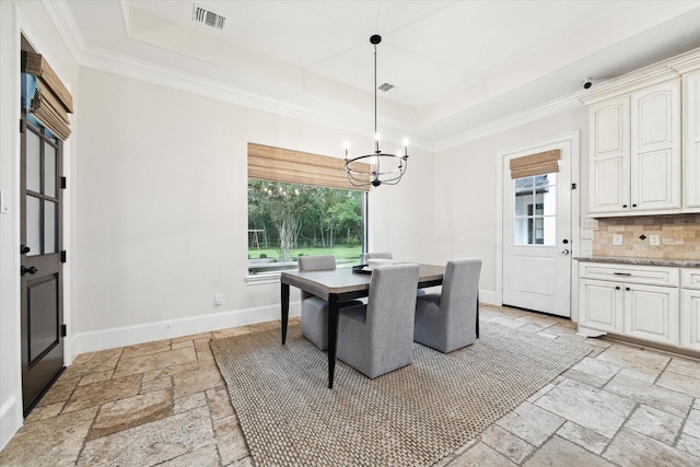 dining room featuring a raised ceiling and an inviting chandelier