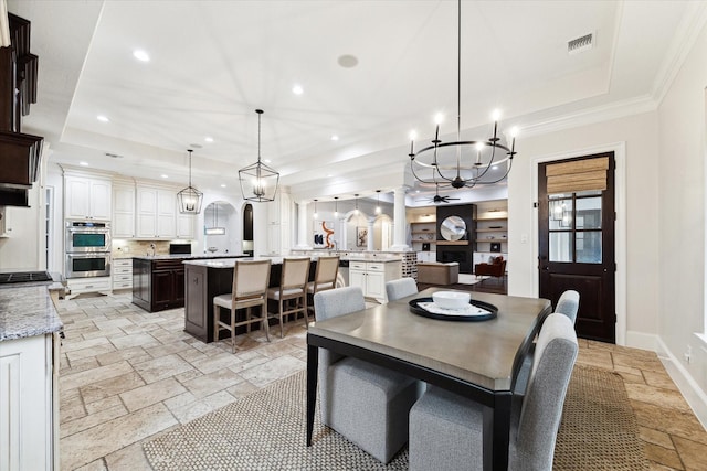 dining space with a raised ceiling and ceiling fan