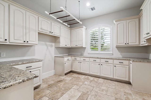 kitchen with white cabinetry and light stone counters