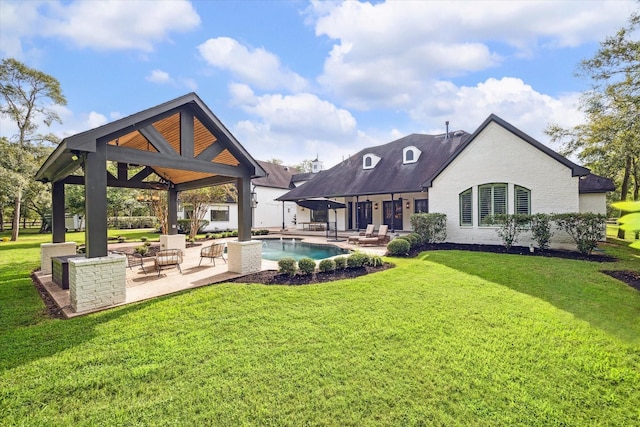 rear view of house with a patio area, a gazebo, and a lawn