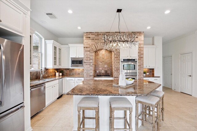 kitchen featuring stainless steel appliances, white cabinetry, and a center island