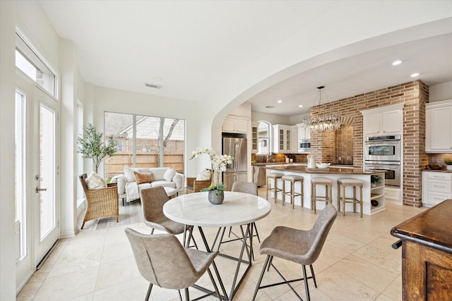 tiled dining room with an inviting chandelier