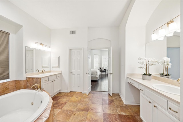 bathroom with a relaxing tiled tub and vanity