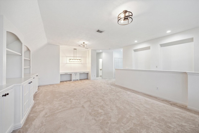 unfurnished living room featuring light carpet, built in features, visible vents, built in desk, and recessed lighting