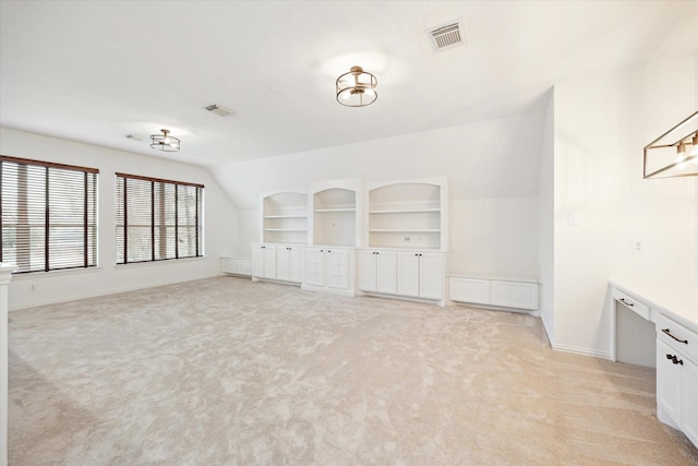 unfurnished room with light carpet, baseboards, visible vents, and built in features