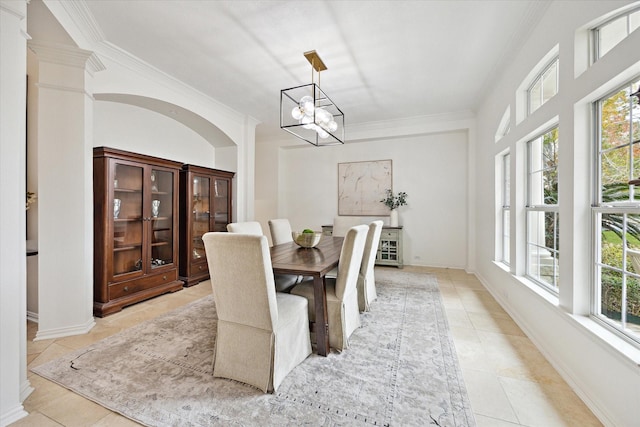 dining room with decorative columns, crown molding, light tile patterned floors, and a chandelier