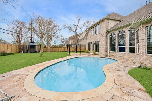 view of swimming pool with a yard and a gazebo