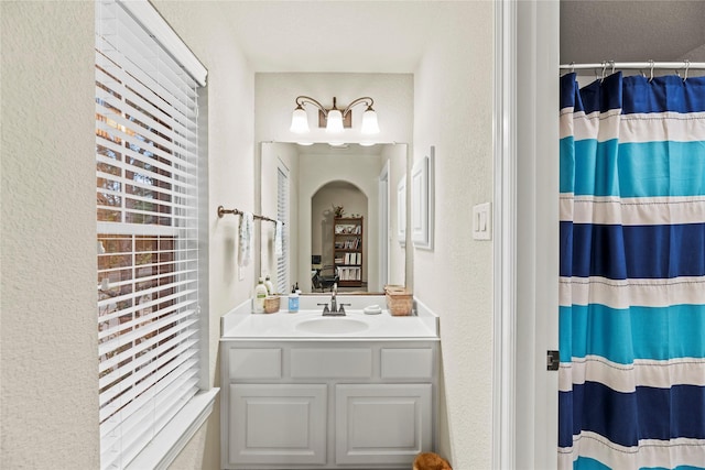 bathroom with walk in shower and vanity