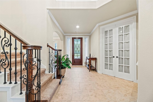 entryway with light tile patterned floors, french doors, and ornamental molding