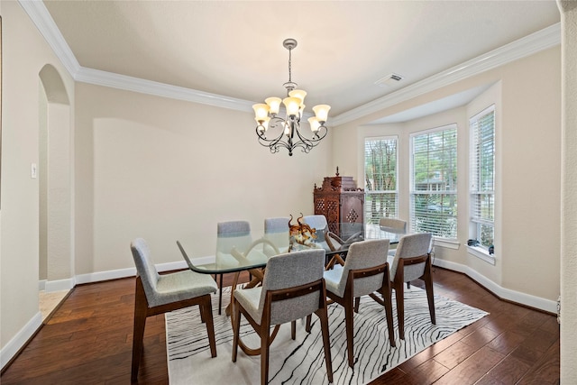 dining room featuring dark wood-type flooring, a chandelier, and crown molding