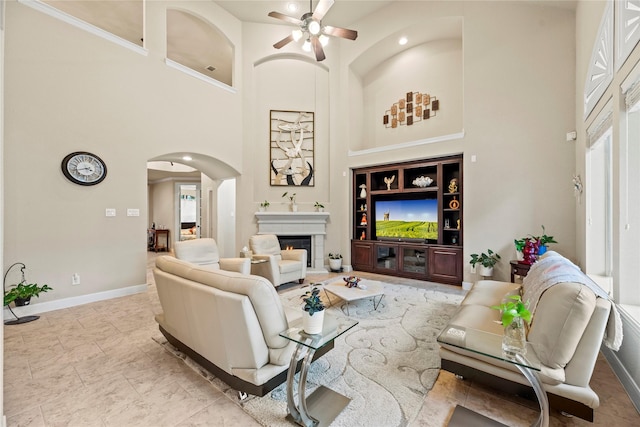 living room with ceiling fan and a high ceiling