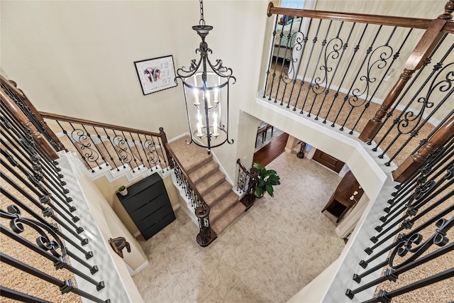 staircase featuring a towering ceiling and a chandelier