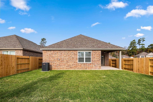 back of property with a lawn, cooling unit, and a patio