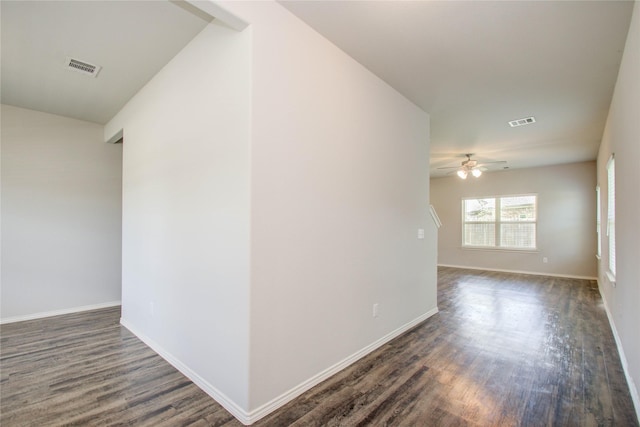 spare room with dark wood-type flooring and ceiling fan