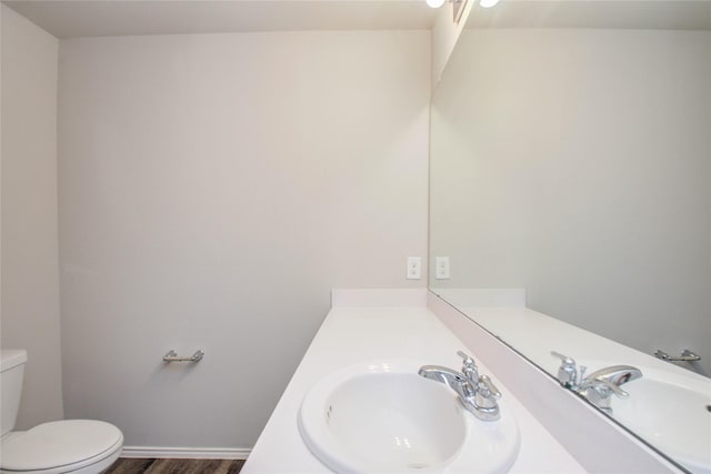 bathroom with wood-type flooring, toilet, and vanity