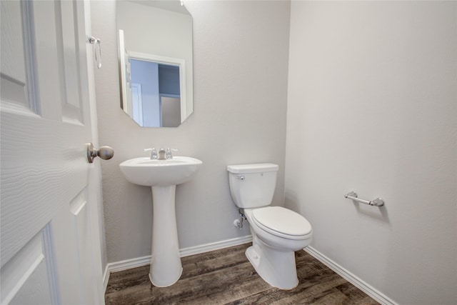 bathroom with toilet, hardwood / wood-style flooring, and sink