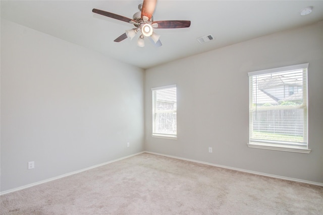 carpeted spare room featuring ceiling fan