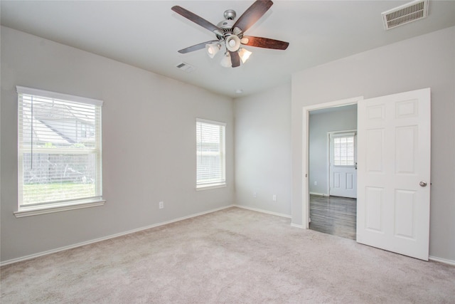 empty room with ceiling fan and light colored carpet