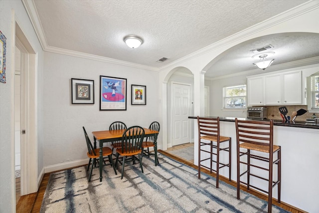 dining area featuring a textured ceiling and crown molding