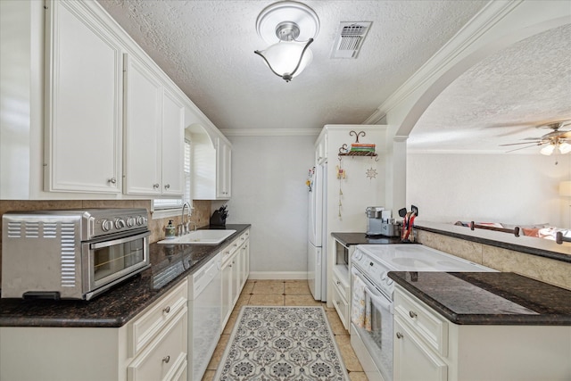 kitchen with sink, crown molding, white appliances, white cabinetry, and light tile patterned floors