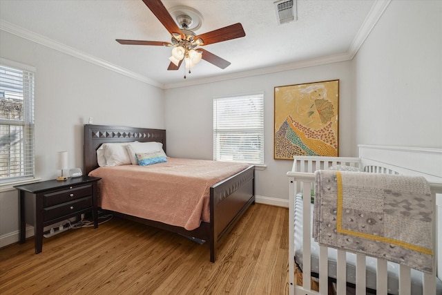 bedroom featuring ceiling fan, multiple windows, and crown molding