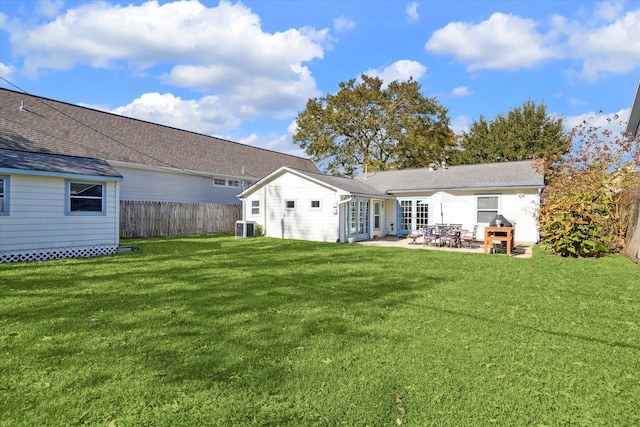 rear view of house featuring a patio area, cooling unit, and a lawn