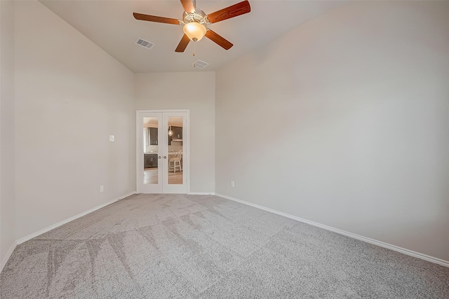 spare room with carpet floors, french doors, a high ceiling, and ceiling fan