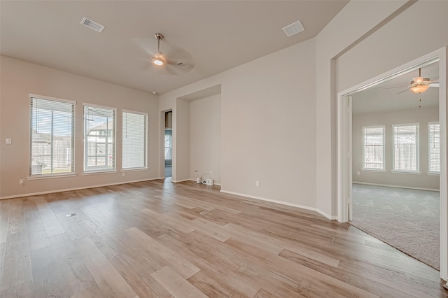 spare room featuring ceiling fan, a wealth of natural light, and light hardwood / wood-style floors