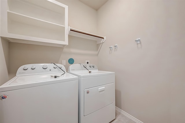 clothes washing area with light tile patterned floors and washer and clothes dryer