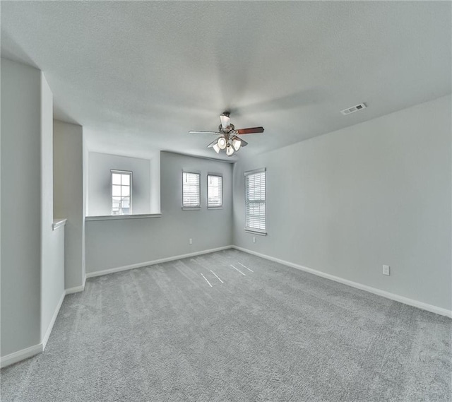 carpeted spare room with ceiling fan