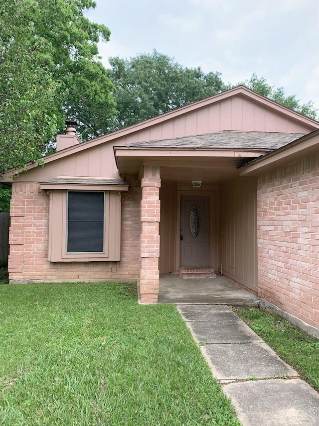 view of exterior entry featuring a yard