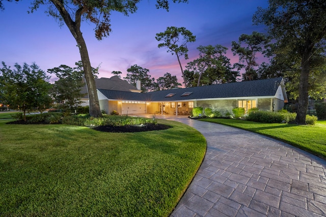 view of front of property with a garage and a lawn