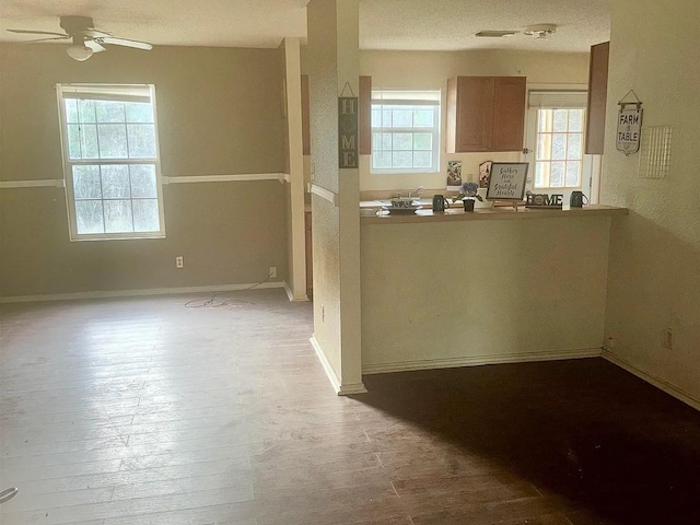 kitchen with ceiling fan, light wood-type flooring, and a textured ceiling