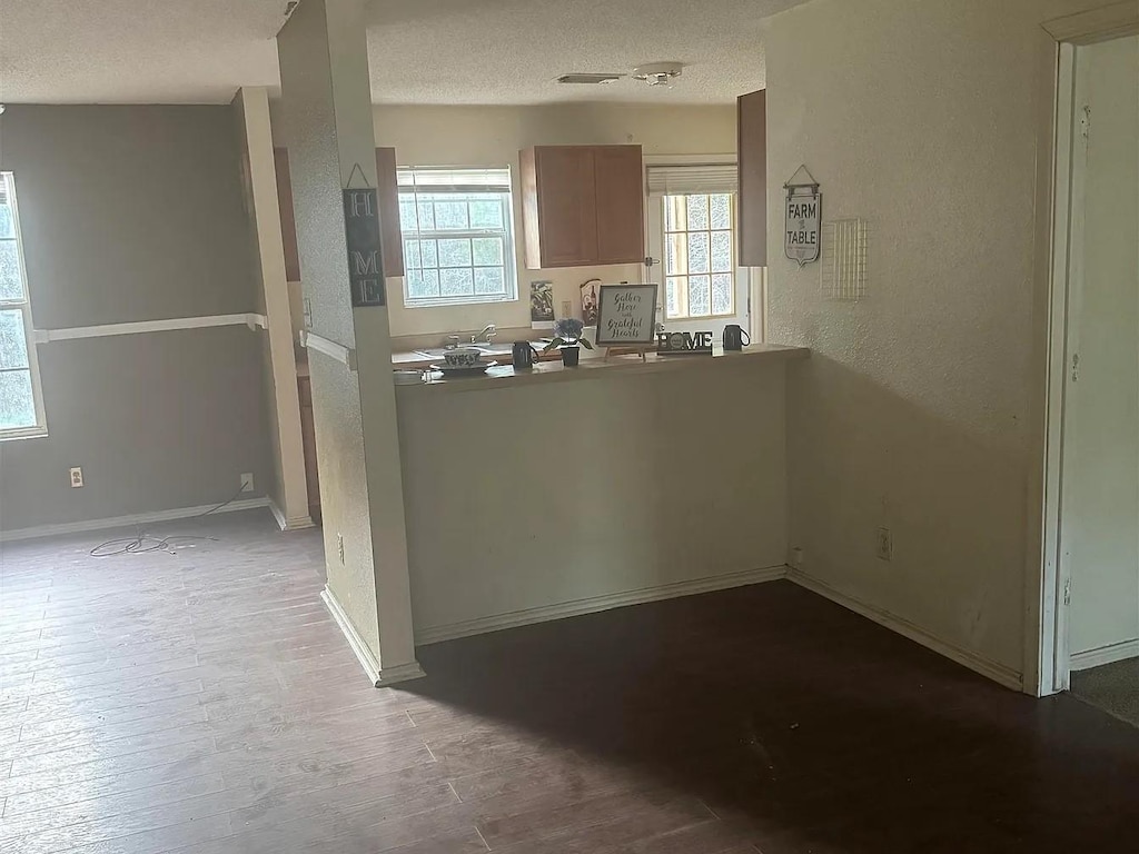 kitchen with a textured ceiling and light hardwood / wood-style flooring