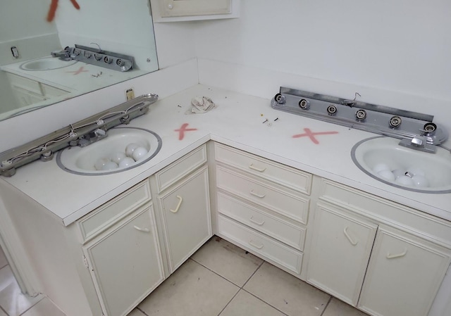 kitchen featuring white cabinets, sink, and light tile patterned floors