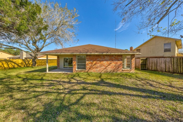 rear view of house featuring a lawn and a patio