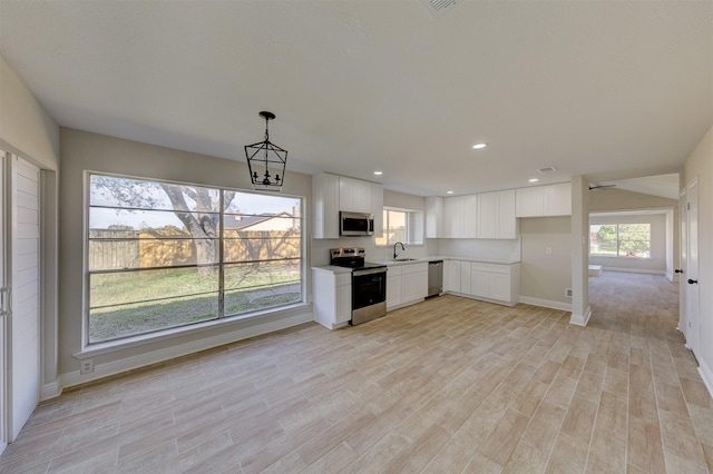 kitchen with plenty of natural light, sink, white cabinetry, and stainless steel appliances