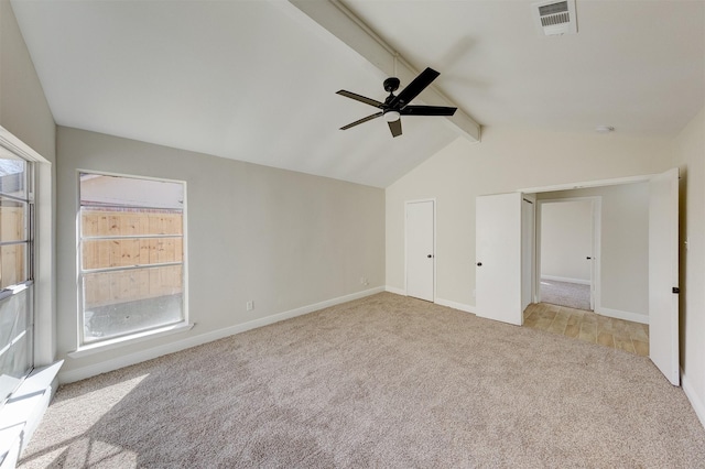 unfurnished bedroom featuring ceiling fan, light colored carpet, and vaulted ceiling with beams