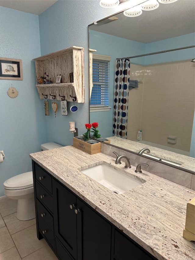 bathroom with toilet, vanity, and tile patterned floors