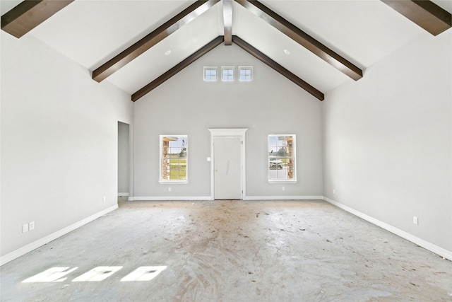 unfurnished living room featuring beam ceiling and high vaulted ceiling