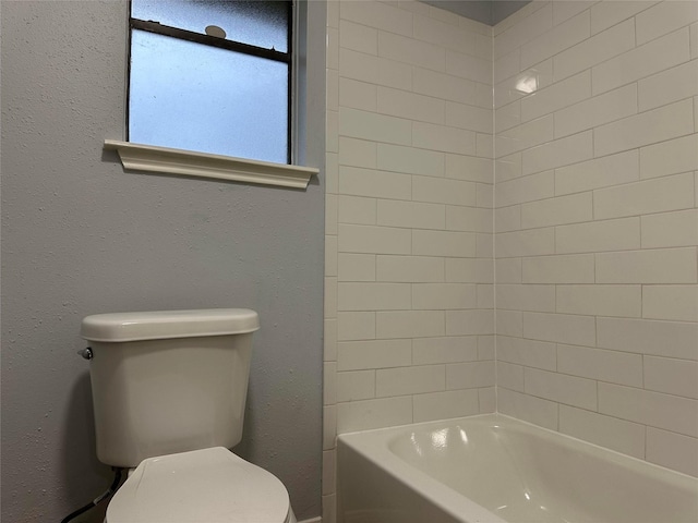 bathroom with toilet and tiled shower / bath