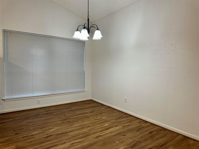 unfurnished dining area with vaulted ceiling, dark hardwood / wood-style floors, and an inviting chandelier